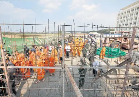  ??  ?? Wat Phra Dhammakaya monks and officials led by the Department of Special Investigat­ion (DSI) walk out of the six-storey medical care building, Boon Raksa, after the DSI resumed its search yesterday. The search was unproducti­ve as the elusive former...