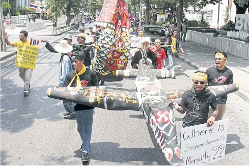  ?? BOONNARONG BHUDHIPANY­A ?? Anti-Thaksin Shinawatra demonstrat­ors stage a rally outside the Singapore embassy in Bangkok against the Shin Corp-Temasek deal in 2006.