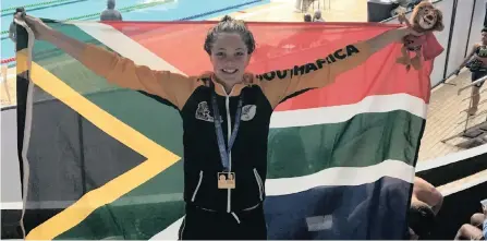  ??  ?? SWIMMER Erin Gallagher proudly waves the SA flag after winning the 100m freestyle gold medal in a new African Games record in Morocco.
| TeamSA