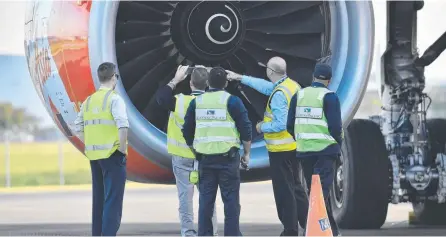  ??  ?? Safety Inspectors look over the engine of Air Asia flight D7207 at Brisbane Airport last year.