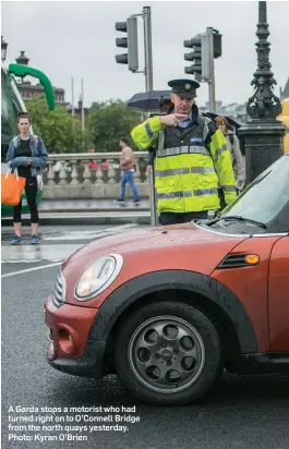  ??  ?? A Garda stops a motorist who had turned right on to O’Connell Bridge from the north quays yesterday. Photo: Kyran O’Brien