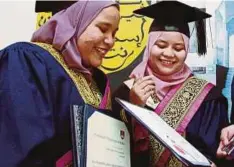  ??  ?? NOR Shuhada (kanan) dan Nurul Shafiqa meraikan kejayaan pada Istiadat Konvokesye­n UiTM Ke-89, semalam.