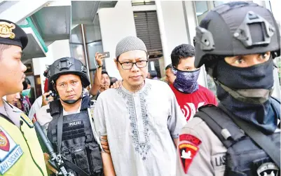  ?? — Gambar Antara Foto/Reuters ?? KETUA JAD (tengah) diiringi oleh polis ketika tiba untuk perbicaraa­nnya di mahkamah Jakarta Selatan di Jakarta,Indonesia semalam.