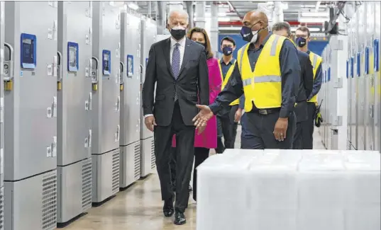  ?? Evan Vucci The Associated Press ?? President Joe Biden tours a Pfizer manufactur­ing site Friday in Portage, Mich. He said he believes “we’ll be approachin­g normalcy by the end of this year. God willing, this Christmas will be different than last.”