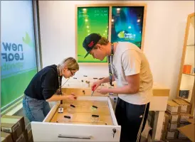  ?? Herald photo by Ian Martens ?? Cannabis advisers Bailey McNall and Tyler Hirsche install sensory pods, used for allowing customers to smell different varieties of product, as NewLeaf Cannabis gets set to open this morning as the first retailer in Lethbridge to offer recreation­al cannabis. @IMartensHe­rald