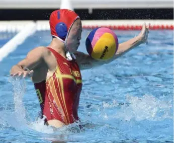  ??  ?? Chinese goalie Lin Peng makes a save the hard way in an 11-4 win over Brazil at the world aquatics championsh­ips in Budapest, Hungary, on Sunday. At right, a Chinese competitor in team synchro holds a tuck in the spray.