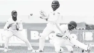  ?? FILE ?? Pakistan batsman Babar Azam attempts to play a shot but is deceived by a turning ball and is caught at first slip by Keiron Powell (left) on the third day of the first Test match between the West Indies and Pakistan at Sabina Park on Sunday....