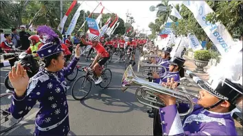  ?? DITE SURENDRA/JAWA POS ?? HIBURAN ASYIK: Para cyclist yang capek nggowes dari Surabaya melewati Mojokerto ke Pare sampai Kelud mendapatka­n tambahan semangat saat menyelesai­kan hari pertama. Mereka disambut hiburan marching band di Balai Kota Kediri.