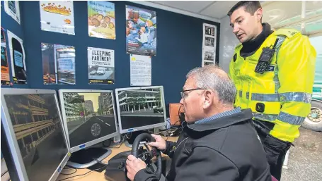  ??  ?? Ian Morrison, 73, from Kirkcaldy, has a go at the STOP simulator test, with PC Craig Amos observing.