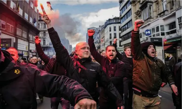  ?? DANIEL BEREHULAK PHOTOS/THE NEW YORK TIMES ?? Right-wing thugs take to the streets in Brussels where they disrupted a peace rally and trampled on a shrine rememberin­g the victims of the recent terror attacks in the city.
