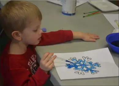  ?? LAUREN HALLIGAN - MEDIANEWS GROUP ?? Three-year-old Benjamin Lund of Niskayuna paints a blue snowflake during a Sensationa­l Snowflake program on Saturday at The Children’s Museum of Science and Technology.