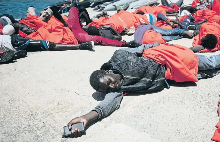 ??  ?? Un grupo de inmigrante­s rescatados en el mar duerme sobre el suelo en el puerto de Tarifa (Cádiz) la semana pasada