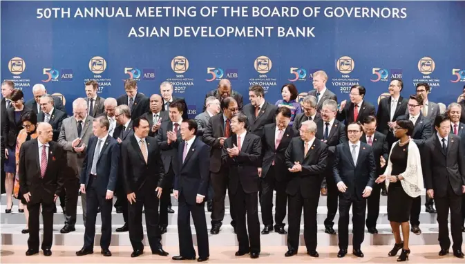  ??  ?? YOKOHAMA: Takehiko Nakao (front row, C), President of the Asian Developmen­t Bank (ADB), and Japanese Finance Minister Taro Aso (front row, 4th L) and others attend a governors’ photo session at the Asian Developmen­t Bank’s annual meeting in Yokohama...