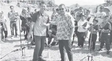  ??  ?? Nizam (right) congratula­tes Lee (left) on his archery achievemen­ts.