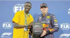  ?? — AFP ?? Red Bull’s Dutch driver Max Verstappen (R) receives the Pole Position Award after the qualifying session on the eve of the Abu Dhabi Grand Prix at the Yas Marina Circuit in the Emirati city of Abu Dhabi.