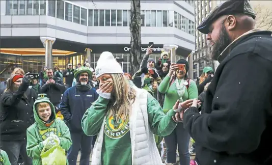  ?? Robyn Pawlos covers her mouth as she cries after saying “yes” to the proposal by longtime boyfriend Ryan McArdle during the 2018 Pittsburgh St. Patrick's Day Parade on Saturday in Downtown. A bus driver for Port Authority of Allegheny County, Mr. McArdle  ??