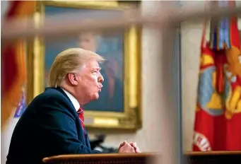  ?? AP ?? As seen from a window outside the Oval Office, President Donald Trump gives a primetime address about border security yesterday at the White House in Washington.