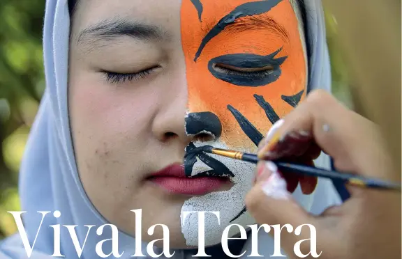  ??  ?? Indonesia
Una studentess­a si fa dipingere il viso con i colori di una tigre per l’earth Day