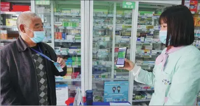  ?? JING XUAN / FOR CHINA DAILY ?? A resident in Meilisi Daur district, Qiqihar, Heilongjia­ng province, has his QR code scanned as he visits a pharmacy.