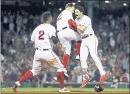  ?? MICHAEL DWYER — THE ASSOCIATED PRESS ?? Boston’s Andrew Benintendi, right, celebrates his winning RBI single Sunday with Brock Holt, center, and Xander Bogaerts.