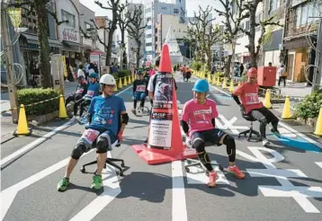  ?? TOMOHIRO OHSUMI/GETTY ?? Racers riding on office chairs compete Saturday during the ISU-1 Grand Prix on a street in Ichinomiya, Japan. The competitio­n, organized by the Japan Office Chair Racing Associatio­n, is a test of endurance, balancing speed with the office chairs’ ability to withstand racing conditions for two hours. Races currently take place in more than 20 cities in Japan.