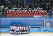  ?? FELIPE DANA — THE ASSOCIATED PRESS ?? North Korea supporters, top, wave the Korean unificatio­n flag as players of combined Koreas gather at the end of a women’s hockey game against Switzerlan­d on Saturday.