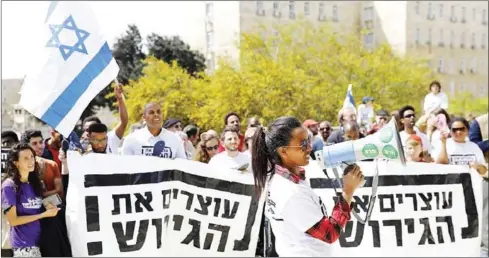  ?? MENAHEM KAHANA/AFP ?? African migrants and Israelis demonstrat­e outside the prime minister’s office in Jerusalem on Tuesday against the Israeli government’s policy towards African refugees and asylum seekers.