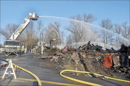  ?? PHOTOS BY MIKE MCMAHON — THE RECORD ?? These file photos from Jan. 14, 2014, show what remains of the Villa Valenti restaurant on Route 150in Wynantskil­l after it was destroyed by a three-alarm fire.