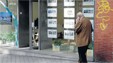  ?? JOSÉ GONZÁLEZ ?? Un hombre habla por teléfono mientras pasa ante el escaparate de una inmobiliar­ia.