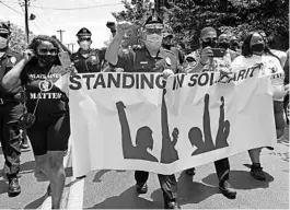  ?? APRIL SAUL VIA AP ?? Camden County Metro Police Chief Joe Wysocki raises a fist while marching with residents and activists last month in Camden, New Jersey to protest the death of George Floyd.