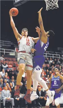  ?? Tony Avelar / Associated Press ?? Stanford’s Reid Travis, driving to the basket against BYU’s Yoeli Childs, had 25 points and 14 rebounds in the win.