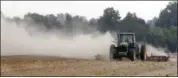  ?? GENE BLYTHE — THE ASSOCIATED PRESS FILE ?? A farm tractor scatters dust as it moves across a field on a farm along state road 82 near Tifton, Ga. Soil is an important natural resource that must be preserved against loss by such forces as wind erosion.