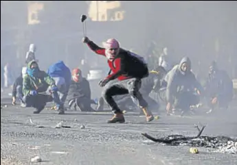  ?? REUTERS ?? A Palestinia­n protester uses a sling to hurl stones towards Israeli troops near Ramallah.