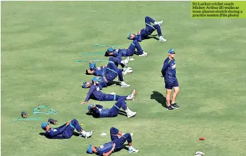  ?? ?? Sri Lanka’s cricket coach Mickey Arthur (R) walks as team players stretch during a practice session (File photo)