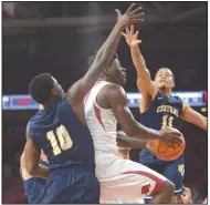  ?? NWA Democrat-Gazette/ANDY SHUPE ?? Arkansas guard Jaylen Barford (center) goes up for a layup Friday as Central Oklahoma guards Marqueese Grayson (left) and Josh Holliday (11) defend at Bud Walton Arena. Visit nwadg.com/photos for more photos from the game.