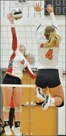  ?? Staff photo/Jake Dowling ?? New Knoxville’s Haley Fledderjoh­ann (8) hits the ball over the net while Minster’s Ivy Wolf (4) attempts to block it during a Midwest Athletic Conference volleyball match on Tuesday.