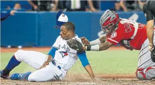  ?? RICK MADONIK/TORONTO STAR ?? Angels’ Martin Maldonado tags the Jays’ Curtis Granderson at plate to snuff tying run in ninth.