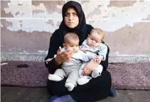  ??  ?? Six-month-old twins Safa and Marwa, who suffer from malnutriti­on, with their mother in Damascus suburb of Eastern Ghouta. (Reuters)