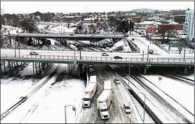  ?? (AP/The Oregonian/Dave Killen) ?? Snow covers the lanes (left photo) at the convergenc­e of Interstate 5 and Interstate 84 Thursday in Portland, Ore., where 11 inches of snow fell Wednesday. Meanwhile, Kamal Rahm, 3 (right), of Carlsbad, Calif., frolics in the snow Thursday at Yucaipa Community Park in Yucaipa, Calif. More photos at arkansason­line.com/224winter2­3/.