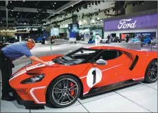  ?? PATRICK T. FALLON / BLOOMBERG ?? A worker cleans a 2018 Ford Motor GT 1967 Heritage Edition at the company’s booth at the Los Angeles Auto Show in California.