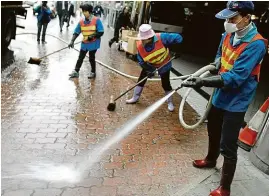  ??  ?? 2003 Dezinfekce chodníku před hongkongsk­ým hotelem Metropole (vpravo) v březnu v roce 2003. Z devátého patra se virus nesl do světa.