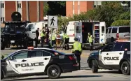  ?? AP PHOTO BY KEITH MINCHIN ?? Police officers and paramedics survey the area of a shooting in Fredericto­n, N.B. on Friday, August 10.