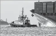  ?? CP PHOTO ?? The tug boat Atlantic Oak leads the container ship YM Modesty as it heads out from Halifax on Friday, Dec. 15, 2017. A new study says the Nova Scotia and federal government­s should shy away from putting public cash into new port infrastruc­ture in the province, and let private firms take most of the risk.