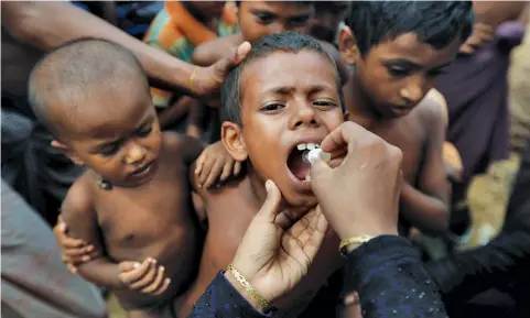  ??  ?? A child in Bangladesh gets an oral cholera vaccine, distribute­d by the World Health Organizati­on