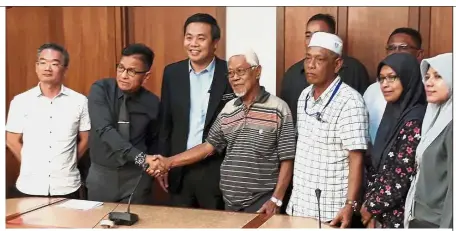  ??  ?? Making up: Norhizam (second from left) shaking hands with Mohamat Umar after issuing an official apology at Seri Negeri Melaka.