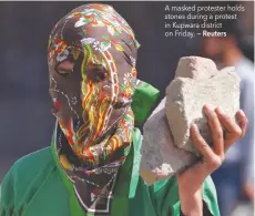  ?? — Reuters ?? A masked protester holds stones during a protest in Kupwara district on Friday.