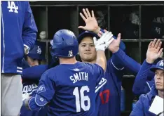  ?? ?? The Dodgers' Will Smith gets a high-five from Shohei Ohtani after hitting a home run in the fourth inning on Tuesday night at Angel Stadium.