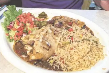  ?? PHOTO BY SARA JACKSON ?? The Steak Burrito is a 12-inch monstrosit­y stuffed with grilled steak and cheese, topped with Hatch Green Chile sauce. It is served with green chile rice and charro beans (not pictured).