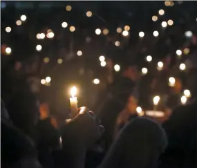  ?? AP PHOTO/WILFREDO LEE, FILE ?? In this Feb. 15, 2018, file photo, attendees hold up their candles at a candleligh­t vigil for the victims of the shooting at Marjory Stoneman Douglas High School, in Parkland, Fla. A Florida law that allows judges to bar anyone deemed dangerous from possessing firearms has been used 3,500 times since its enactment after the 2018 high school massacre. An Associated Press analysis shows the law is being used unevenly around the state.