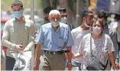  ?? Reuters ?? People wearing face masks to prevent the spread of the coronaviru­s disease (COVID-19) walk in downtown Cairo on Sunday.